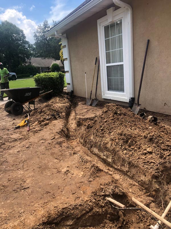 Trench excavated along a home's foundation for drainage